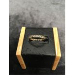 A gold eternity ring with white stones. (One stone missing).