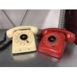 Two vintage telephones in cream and red.