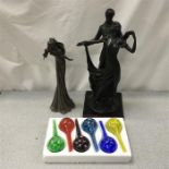 Three resin figurines along with a set of decorative glassware