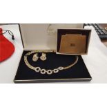 A boxed Fior choker together with a pair of clip on earrings and a handbag shaped mirror compact.