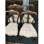 A set of four Edwardian mahogany chairs. carved backs shaped legs