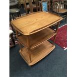 A mid 20th century Ercol Blonde three tier tea trolley.