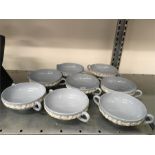 A set of eight light blue and white floral slip Wedgwood twin handled soup bowls.