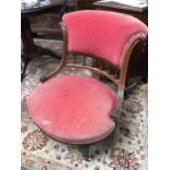 A pink upholstered roll back bedroom chair.