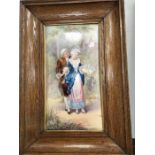 A late 19 century french oak framed painted plaque of a couple in detailed conversation, ample
