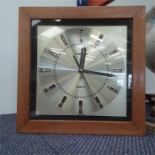 A wall hanging wooden surround Toshiba Quartz clock.