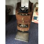 A wooden jewellery box with bracelets, earrings and other related items