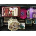 A box of collectables containing books, advertising tins, postcards etc.