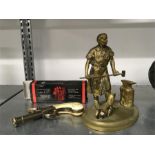 A reproduction brass blacksmith figure together with a reproduction pistol.