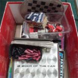 A box containing various items to include chess pieces, car bulbs, magazines and ornaments.