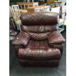 A modern burgundy leather recliner armchair.