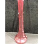 A large lily vase in cranberry glass.