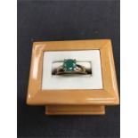 A solitaire emerald ring set in 9ct gold (size P).