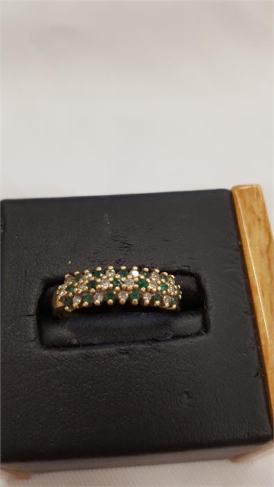 A 9 carat gold diamond and emerald ring.