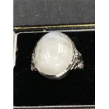 A large cabochon moonstone ring set in silver.