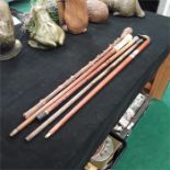 Five walking sticks including two with silver knops and a duck’s head in brass.