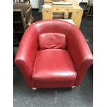 A red modern bucket back leather armchair.