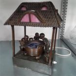 A Spelter lamp designed as three children looking over a well (af).