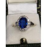A 9ct gold ring set with large central blue stone surrounded by white stones. (Not tested).