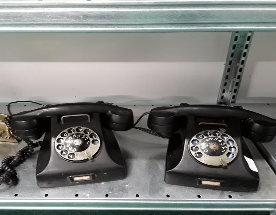 Two vintage black telephones.