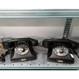 Two vintage black telephones.