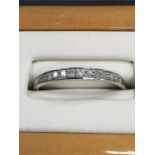 A white gold and diamond half eternity ring.