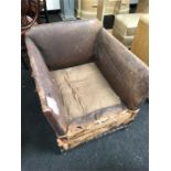 A leather low armchair in need of re upholstery.