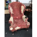 A Victorian winged back armchair in need of re upholstery.