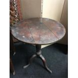 A small antique design dark oak tilt top table.