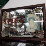 A large Coca Cola mirror advertising sign