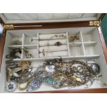 A wooden jewellery box containing a quantity of costume jewellery.
