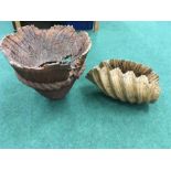 Two pieces of carved wood, one in the shape of a clam shell.