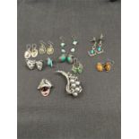 A Butler and Wilson brooch and one other. Nine pairs of earrings including silver set with various