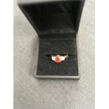 An 18ct gold ring set with two diamonds and a central red stone.