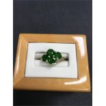 A 9ct gold ring set with four green stones (chromium oxide).