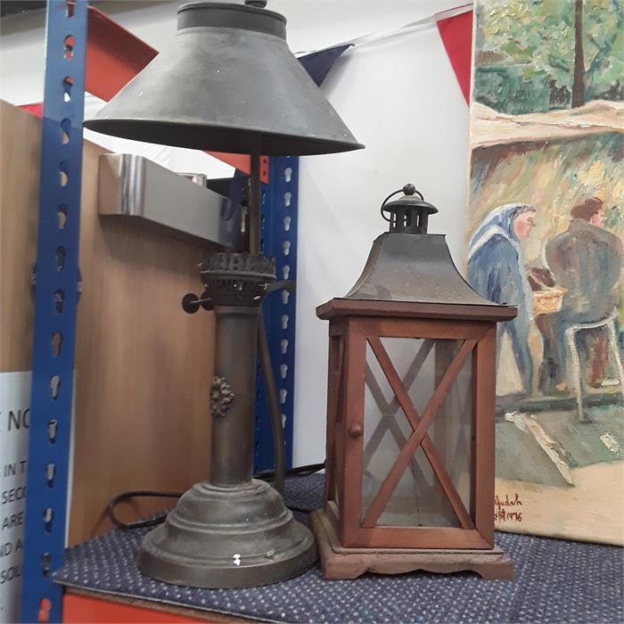 A brass lamp with brass shade and a wooden and metal glass pane lantern.