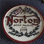 A round cast Norton sign.