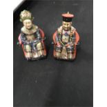 A pair of oriental seated figures, 11.5” high.