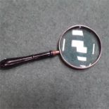 A silver plate 56" magnifying glass.