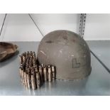 A Military Helmet together with brass bullet casing belt.