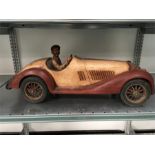 A large model of a vintage car with wire wheels and rubber tyres.