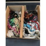 Two boxes of costume jewellery, mainly beads.