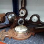 Three wooden mantle clocks together with two barometers.