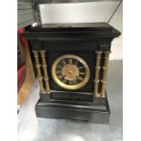 A Victorian black slate mantle clock. with gilded face and side