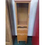 A narrow modern three drawer cabinet with glazed cupboard door to top.