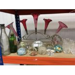 A collection of decorative paperweights, vintage bottles and other glassware.
