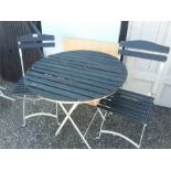 A metal and wood slat bistro table with two chairs.