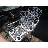 A pair of aluminium garden armchairs.