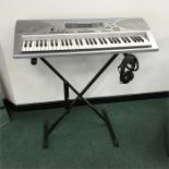 A Casio CTK-691 keyboard with stand and headphones.