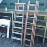 A wooden step ladder with a wooden triple ladder.